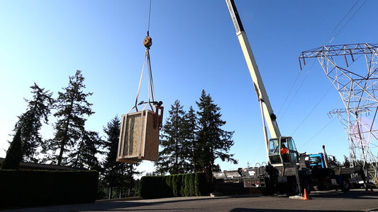 crane taking a safe into a house