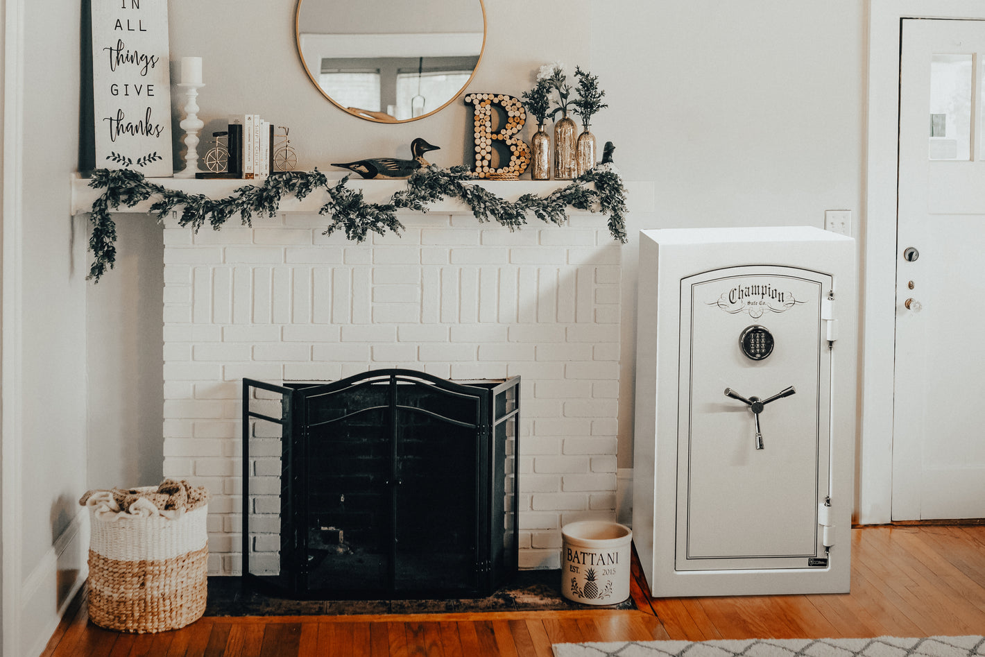 A smaller white gloss Home Safe from Champion Safe, Its placed next to a fireplace on hardwood floors to let you know that a home safe can be placed on wood floors and can be a piece of furniture to add decor to a room while still being a secure safe.